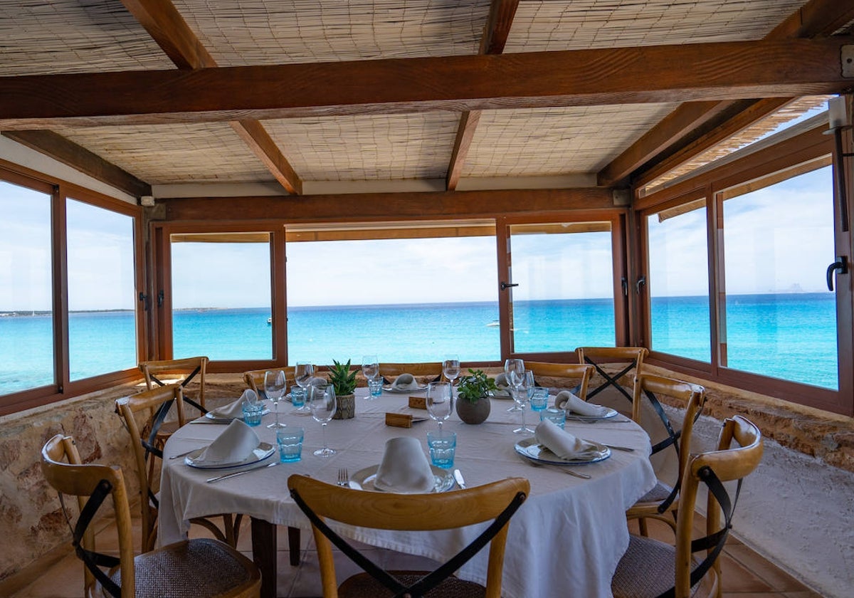 Una mesa de Es Molí de Sal, con el Mediterráneo tras el ventanal