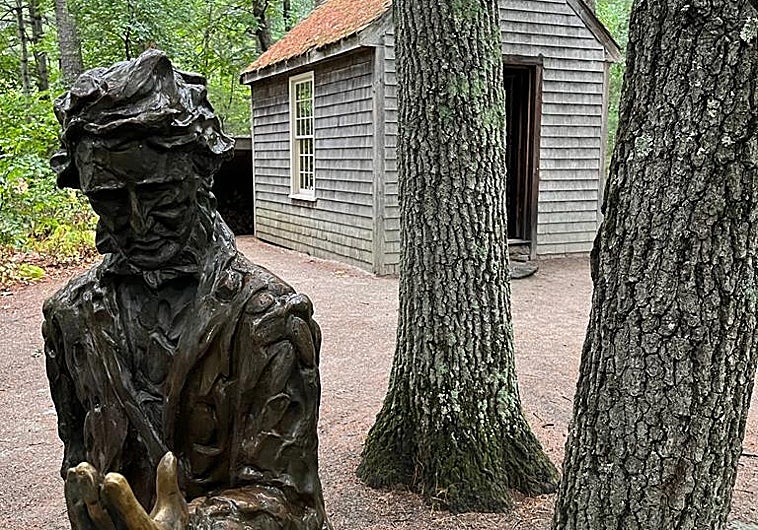 Escultura de Thoreau junto a una réplica de la mítica cabaña del lago Walden, en Concord