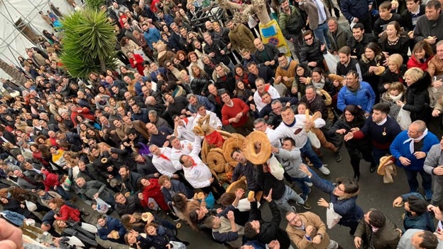 Al paso de los santos se lanzan roscos que cogen los participantes de la procesión en Olula del Río.