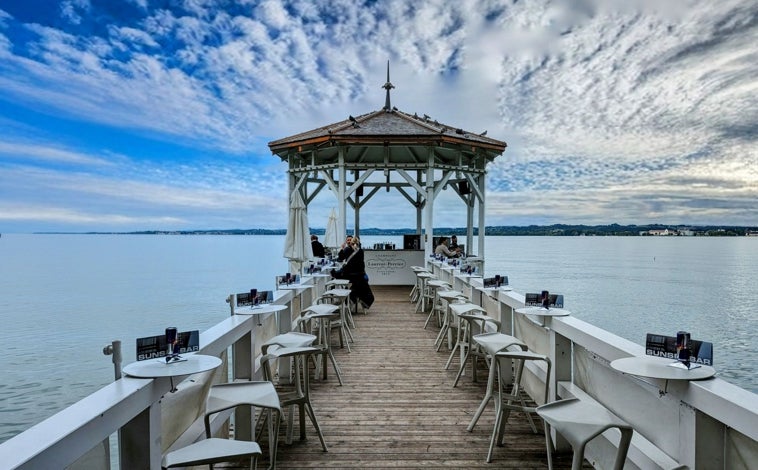 Imagen principal - Christoph ordeña a sus vacas dos veces al día, y con la leche (más de cuatrocientos litros) elabora a media mañana dos enormes quesos. En la foto superior, el lago Constanza en Bregenz. Sobre estas líneas, la terapia con caballos en el monasterio benedictino de Propstei St. Gerold