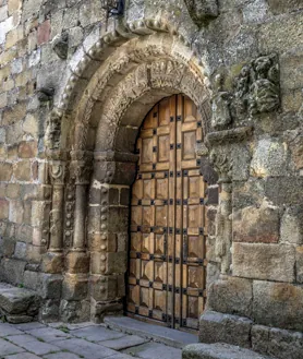 Imagen secundaria 2 - Vista del pueblo de Hoyos, una de sus calles y portada románica de la iglesia de Nuestra Señora del Buen Varón 