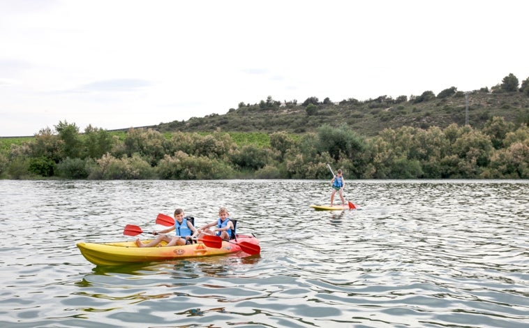 Imagen principal - En la foto superior, kayak en el Mar de Aragón. Junto a estas líneas, los bungalós del Taiga Lake Caspe. A la derecha, las runas de la ermita de la Magdalena