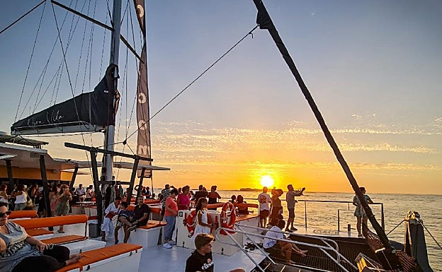 Los viajeros disfrutan de la puesta de sol desde el Catamarán Pura Vida