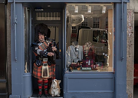 Imagen secundaria 1 - Con 1.814,2 metros de longitud, la Royal Mile (en la foto superior) es la calle más famosa de Edimburgo. Junto a estas líneas, un 'piper' y un perro 'influencer' (Marcel le Corgi) en una tienda. A la derecha, Calton Hill, justo donde acaba Princes Street.