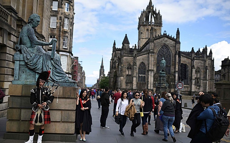 Imagen principal - Con 1.814,2 metros de longitud, la Royal Mile (en la foto superior) es la calle más famosa de Edimburgo. Junto a estas líneas, un 'piper' y un perro 'influencer' (Marcel le Corgi) en una tienda. A la derecha, Calton Hill, justo donde acaba Princes Street.