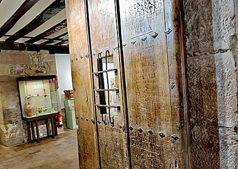 Imagen secundaria 1 - Las inscripciones de los presos en la puerta que se encuentra en el museo de Nájera