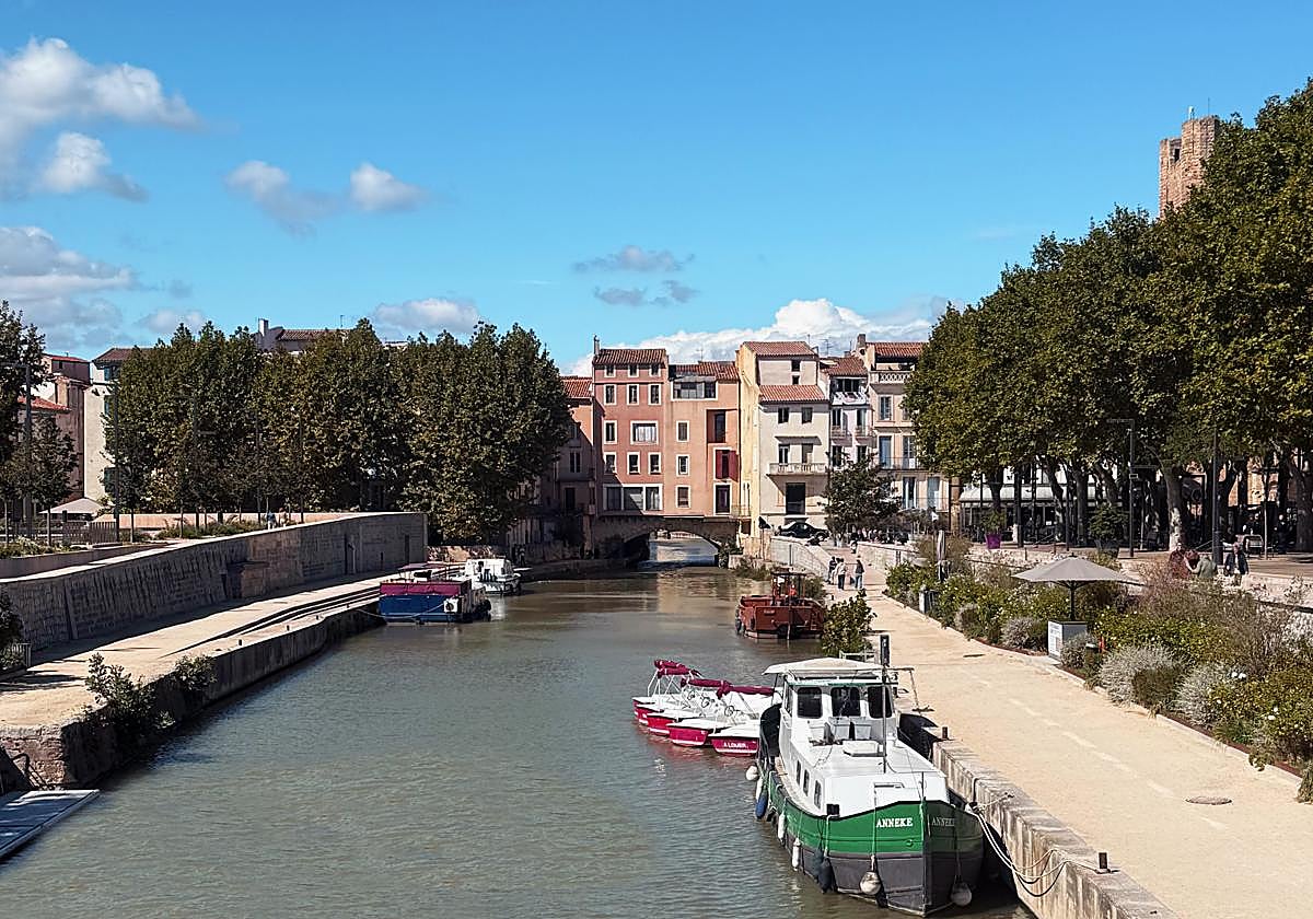 Imagen del canal de la Robine en Narbona con el Puente de los Mercaderes de fondo