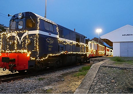 Imagem Secundária 1: Moradores celebram o Natal em evento vespertino (acima); o trem histórico da Vogue (canto inferior esquerdo); e uma das ruas do centro da cidade com guarda-chuvas e luzes de Natal (canto inferior direito)
