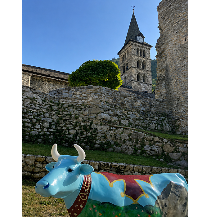 Atracción de una vaca decorada, y de fondo la Iglesia de Santa María de Arties.