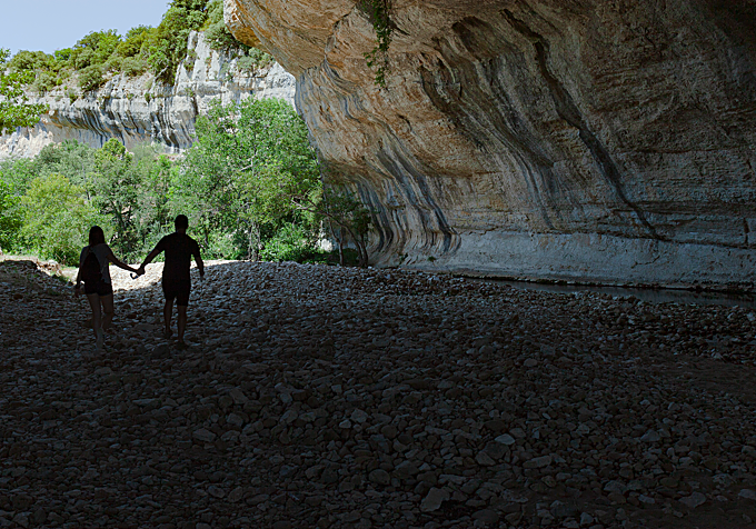 Pareja explorando la parte inferior del arco de piedra