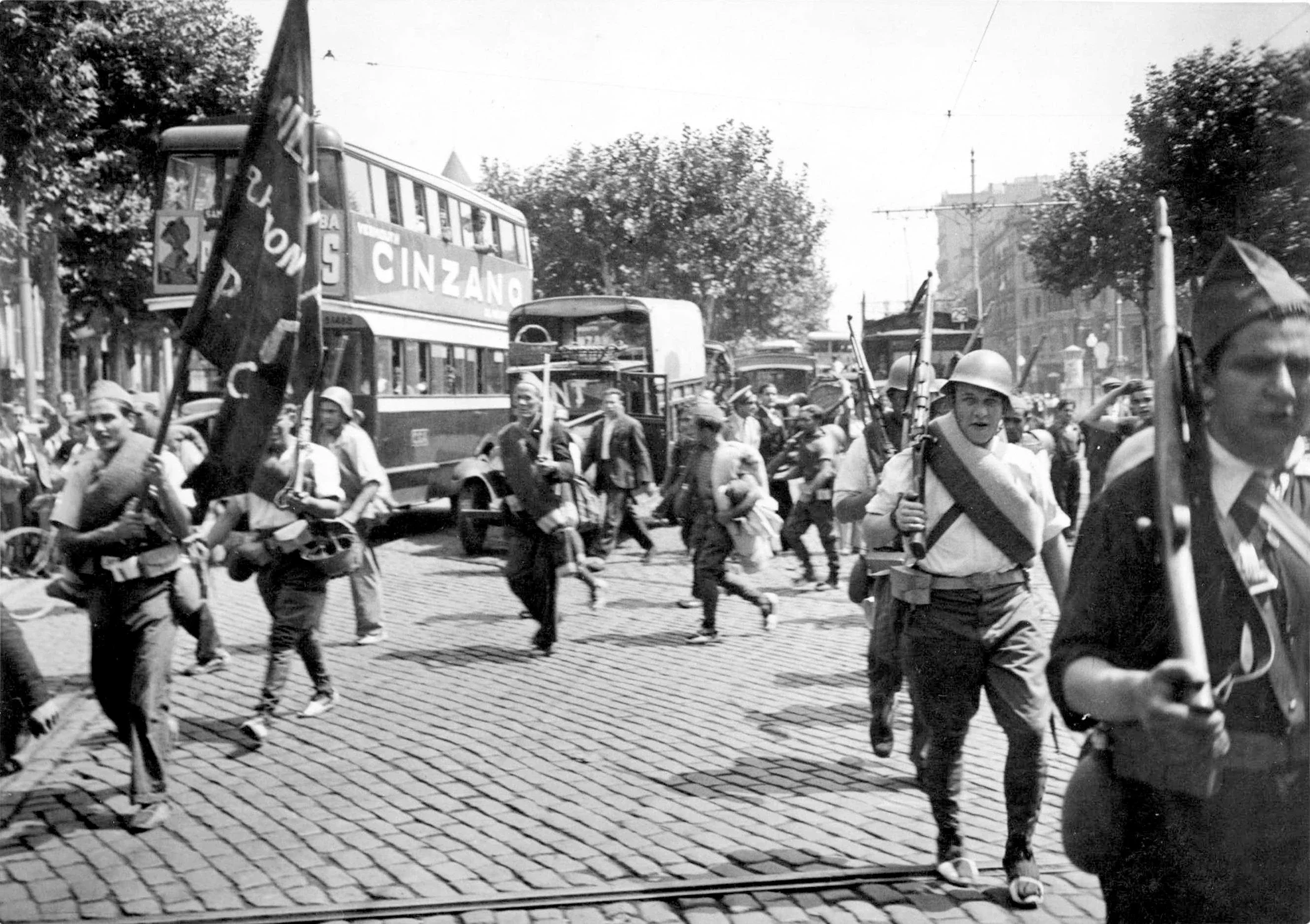 Milicianos que se dirigen al frente desfilan por las calles de Barcelona.