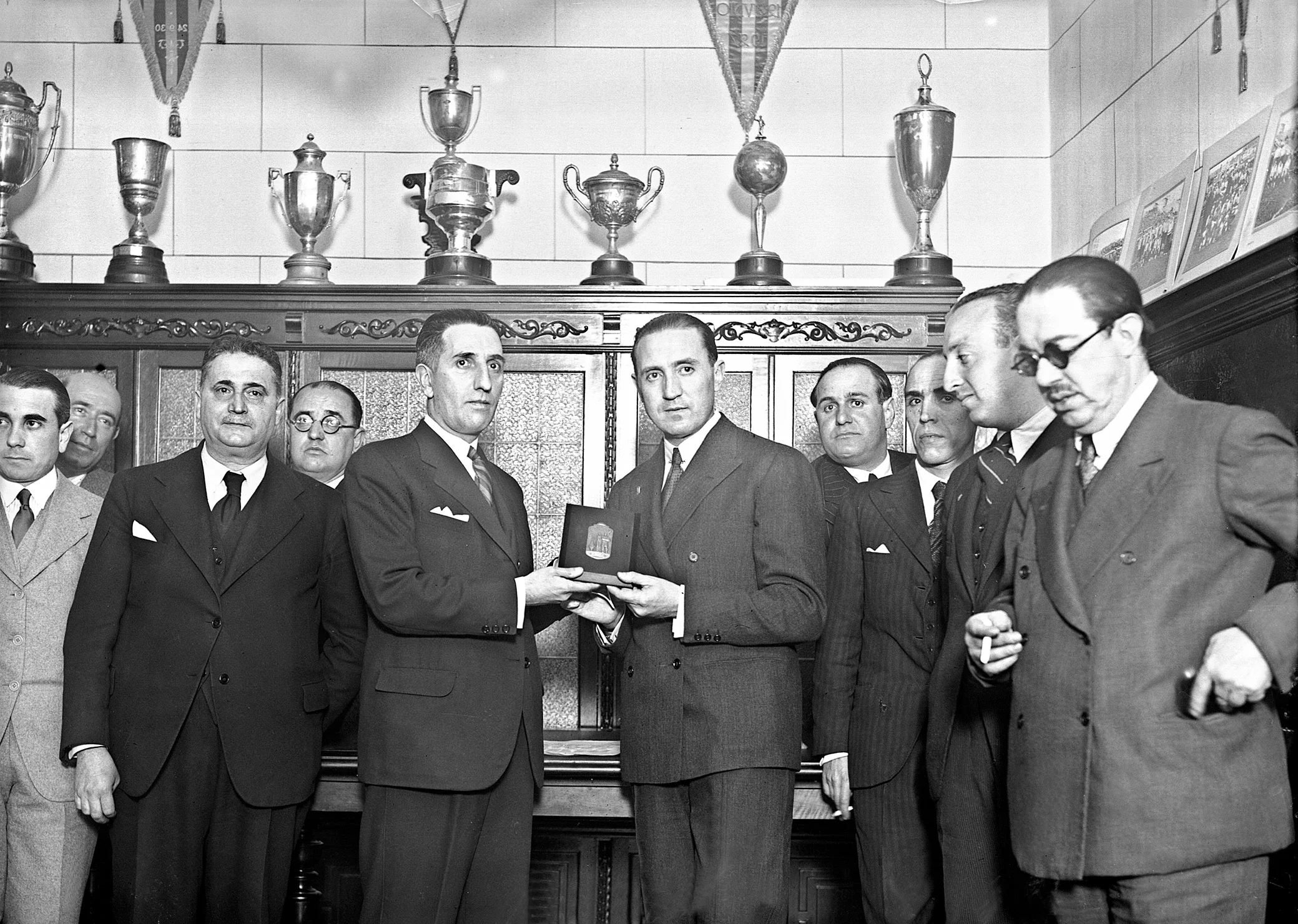 El exfutbolista y secretario de la Junta directiva del Madrid, Santiago Bernabéu (a la derecha), recibe la medalla al Mérito Futbolístico, en los salones de la Federación Castellana de Fútbol