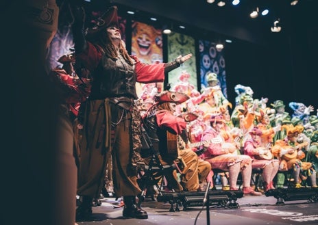 Imagen secundaria 1 - Dos imágenes del Coro de Huelva en el Carnaval Colombino y uno de los sombreros diseñados para los pregoneros