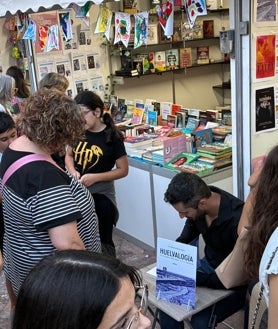 Imagen secundaria 2 - Lorenzo Silva, en la plaza conversando con el autor onubense Mario Marín y en su encuentro con los lectores. / Luis Alfonso Morales firmando su primera obra, 'Huelvalogía'
