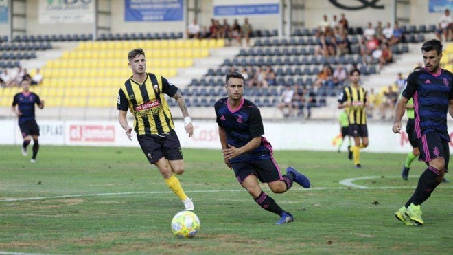 Manu Torres ante Gerard Vergé en un amistoso entre el San Roque de Lepe y el Recre