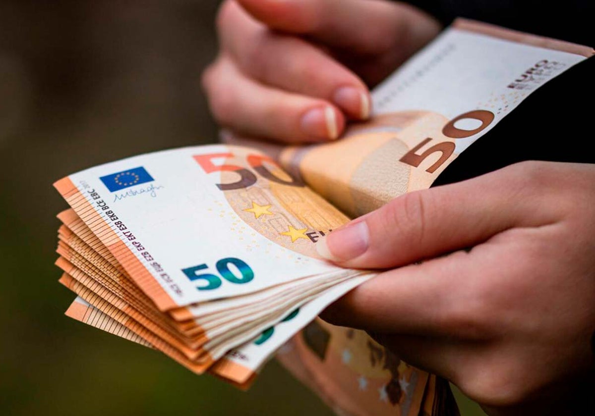 Una mujer con billetes de 50 euros