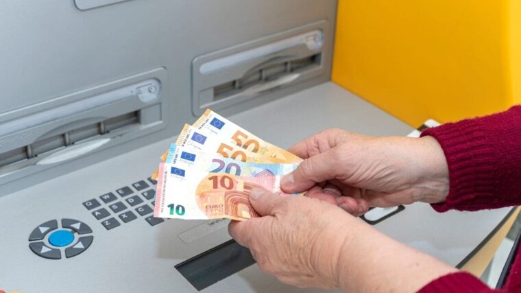 Imagen de archivo de una persona sacando el dinero de la pensión de un cajero automático de un banco