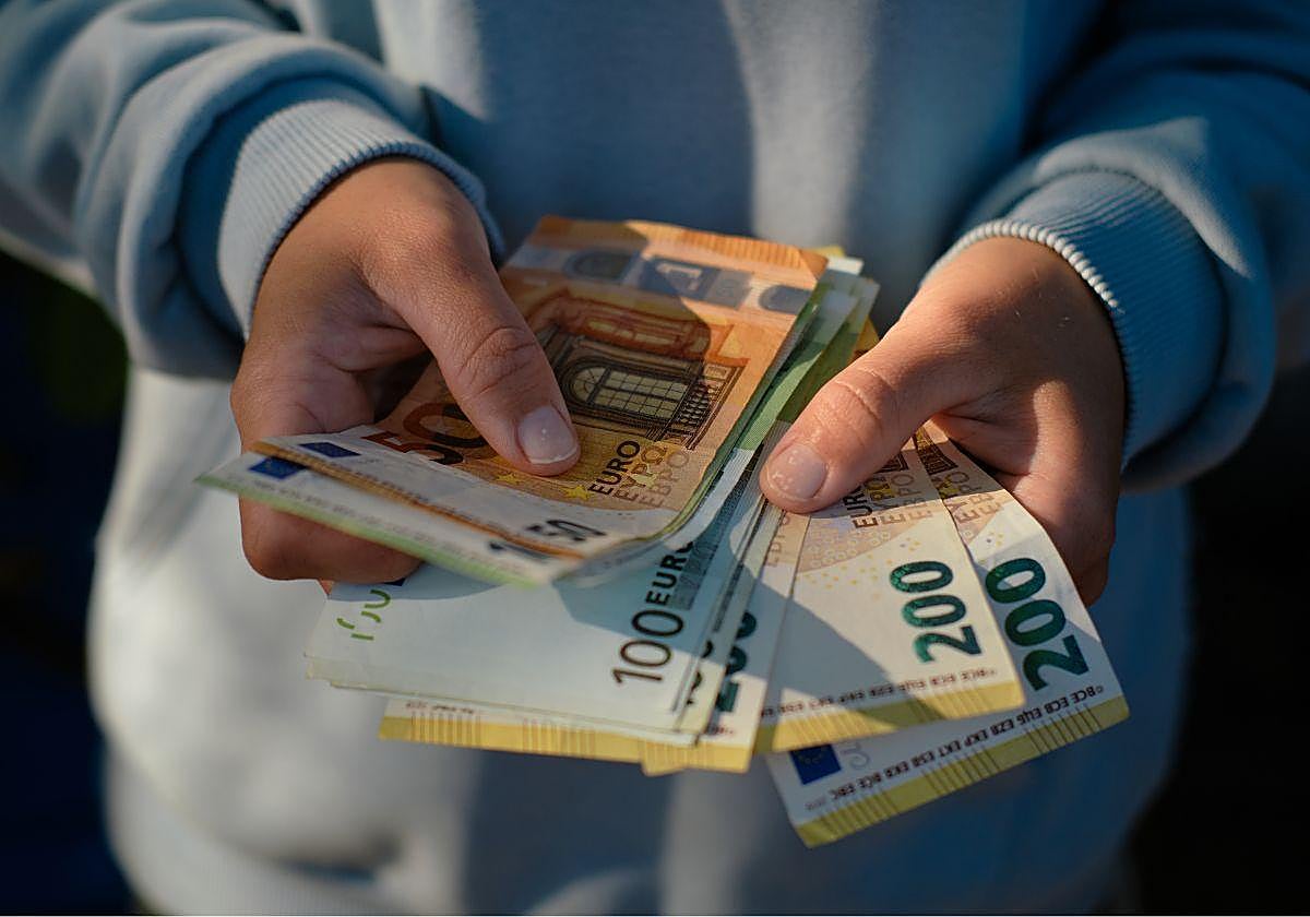 Imagen de archivo de una persona con varios billetes de euro