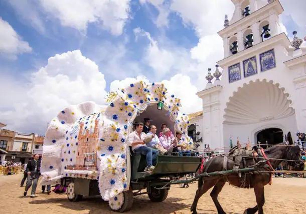 Un carro tradicional pasa frente a la ermita del Rocío