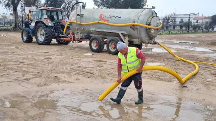 Un operario aspira el agua de los charcos en la aldea