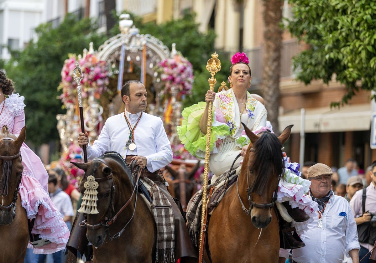 El presidente y la hermana mayor de Emigrantes, delante de la carreta del Simpecado