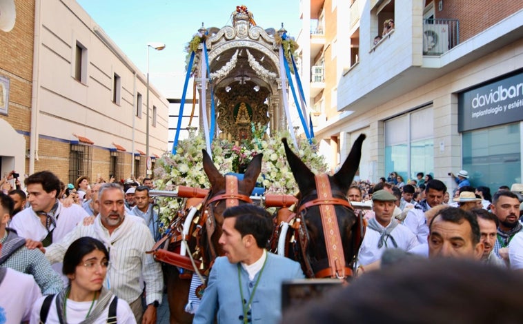 Imagen principal - En la imagen superior, el Simpecado avanza por las calles; justo debajo a la izquierda, antes de su entronización y a la derecha, el hermano mayor durante la misa de romeros.