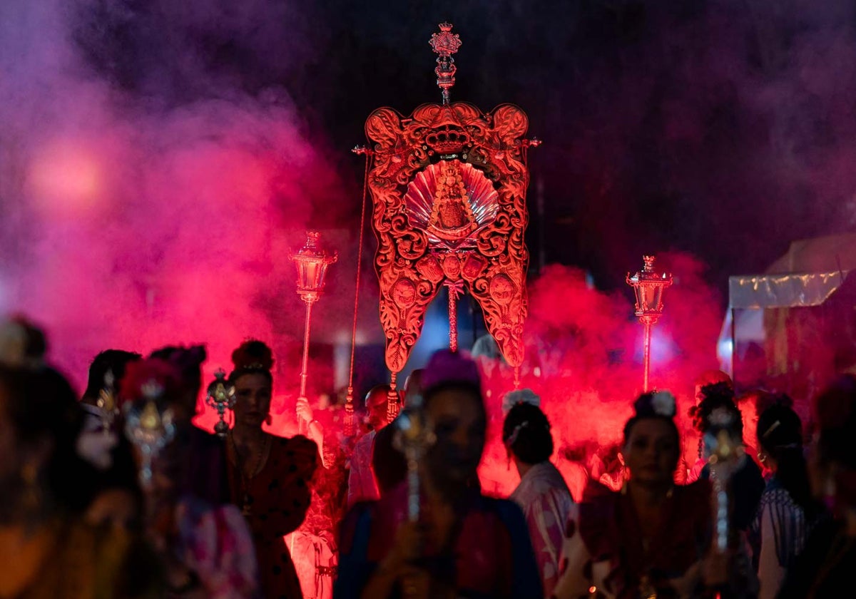 El simpecado de Emigrantes a la luz de las bengalas