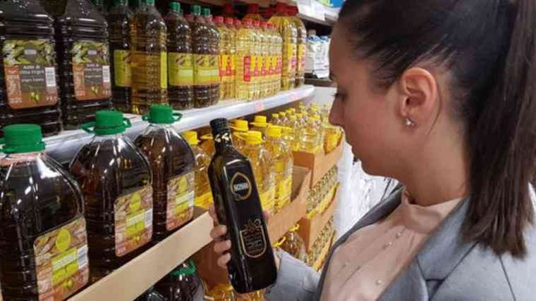 Una clienta compra aceite en un supermercado