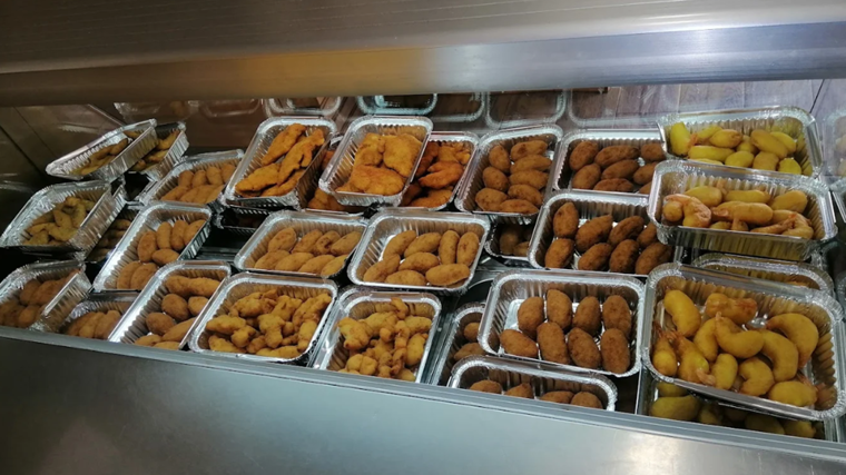 Expositor con bandejas de comida en el Asador Palacios