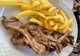 Chuletitas de cordero lechal a la brasa con patatas, uno de los platos estrella de la carta de Taberna El Condado en Huelva