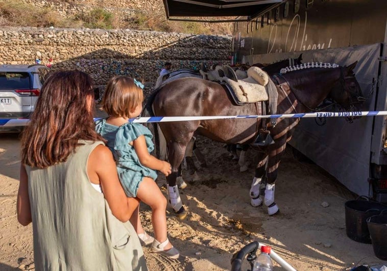 Una mujer muestra a una niña uno de los caballos de la rejoneadora Lea Vicens