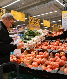 Imagen secundaria 2 - Arriba, ambiente a las puertas del supermercado Supeco. Abajo, dos clientes miran el precio del jamón y otro selecciona los tomates para su compra