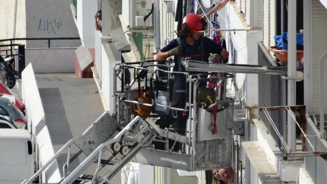 Bomberos ayudan a una mujer a salir por el balcón de su domicilio para ser trasladada al hospital