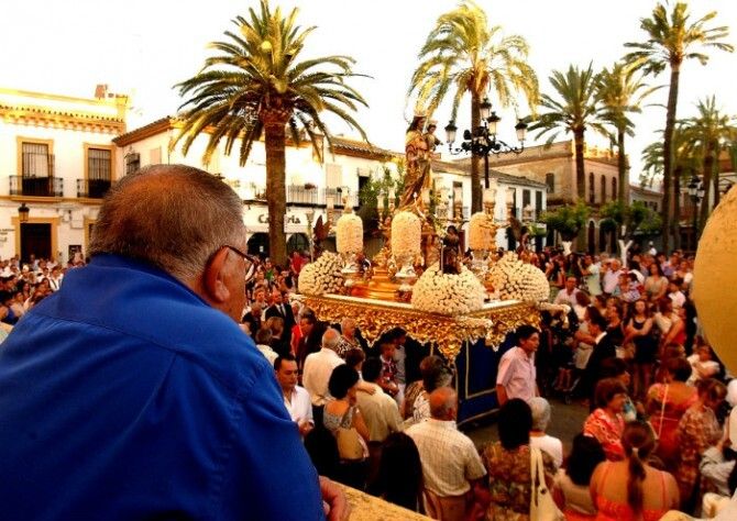 La procesión de María Auxiliadora reúne en La Palma a cientos de devotos de toda Andalucía