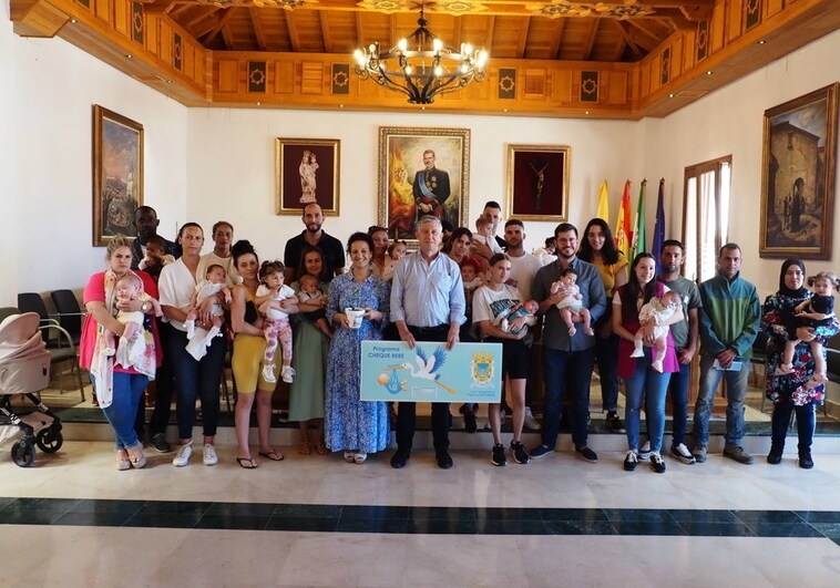 Carmelo Romero, alcalde de Palos de Frontera, con las familias que han recibido el 'cheque bebé'