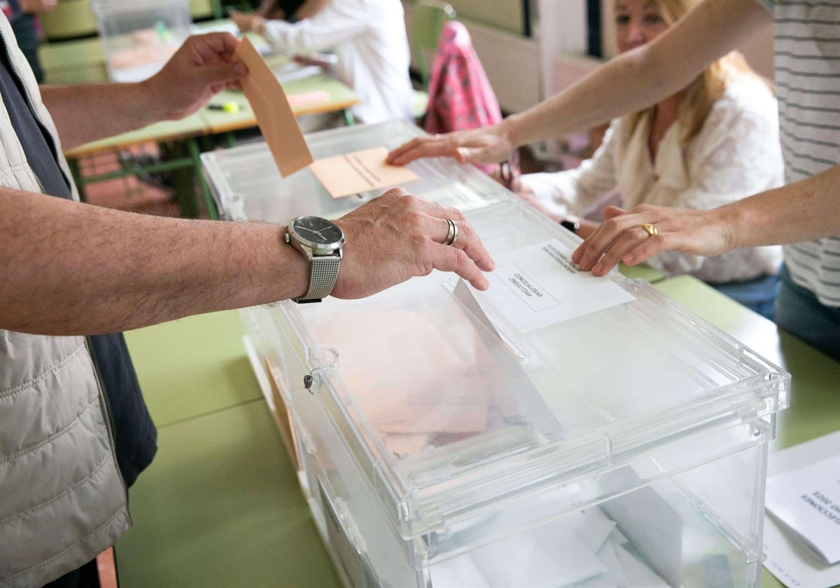 Una persona depositando un voto en una urna electoral