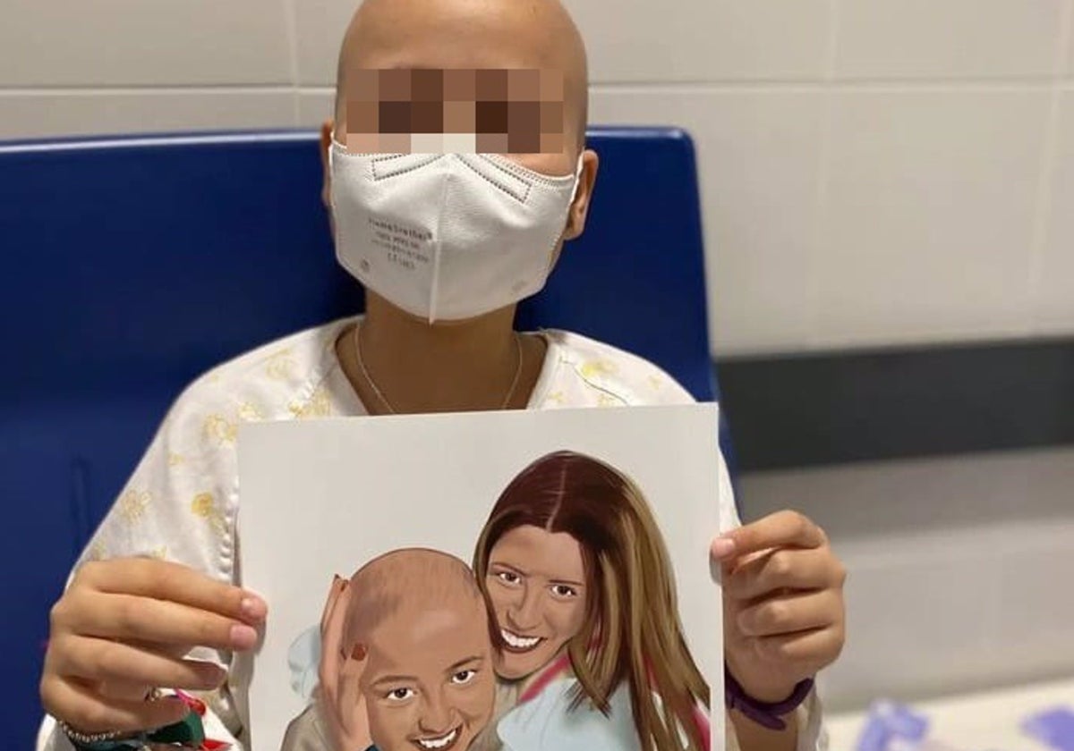 Paula posa con un dibujo en el que aparece junto a su madre y que fue un regalo.