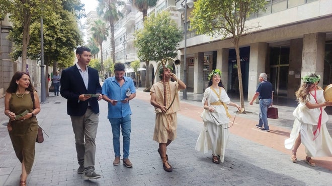 Tres componentes del grupo de recreación paseando esta mañana por las calles de Huelva