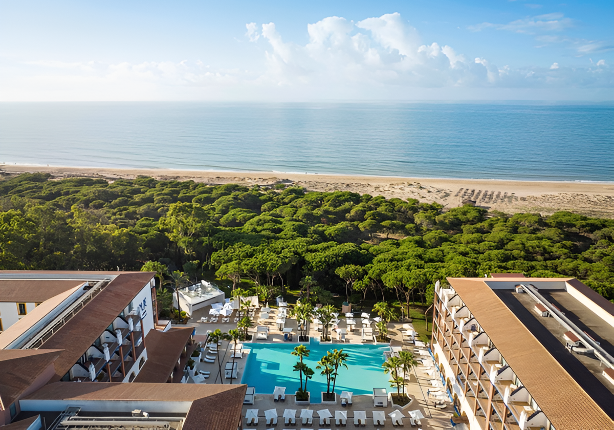 Un frondoso pinar separa al hotel de la playa isleña de Santana