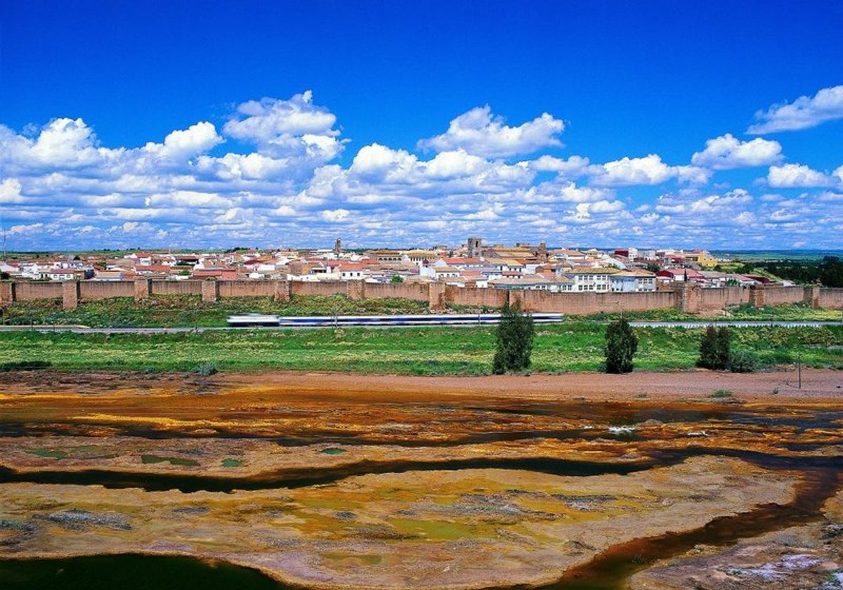 Niebla, parapetada tras sus murallas, con el río Tinto en primer termino