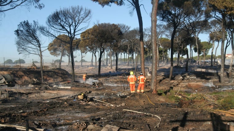 Efectivos del Consorcio Provincial de Bomberos extinguen el fuego en el asentamiento chabolista de Lucena arrasado este sábado