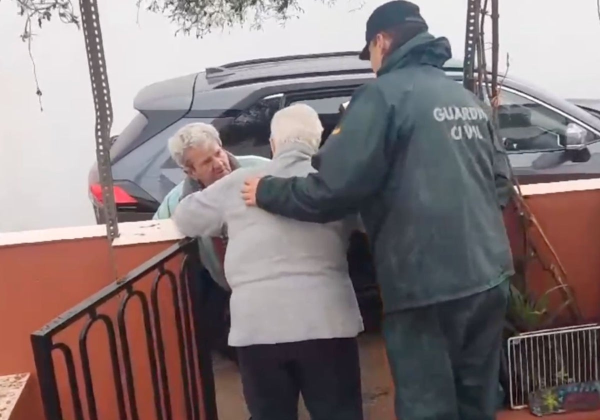 Un agente de la Guardia Civil ayuda en el desalojo a unos vecinos de Cueva de la Mora