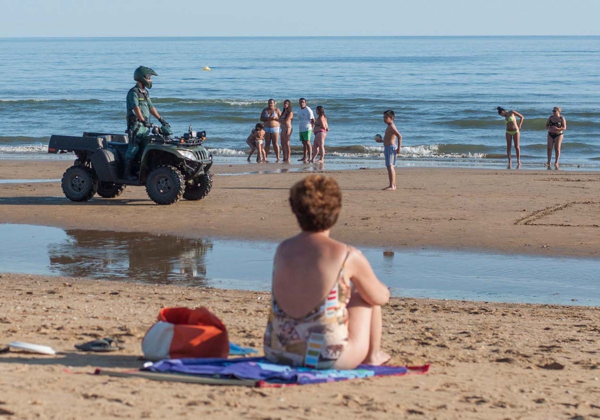 En una imagen de archivo, un guardia civil patrulla por la playa de Punta Umbría