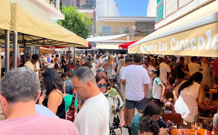 Imagen principal - Arriba, ambientazo en la Feria de Día y sobre estas líneas, equilibrio sobre la cucaña y flores para la patrona al paso de la imagen