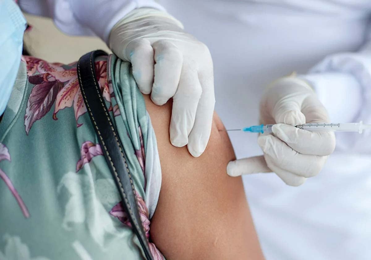 Una mujer se vacuna de la gripe en un centro sanitario