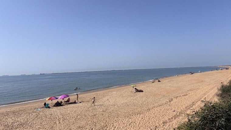 Playa de Mazagón, con el espigón Juan Carlos I al fondo