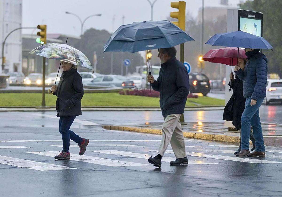 Onubenses caminando por la ciudad bajo la lluvia