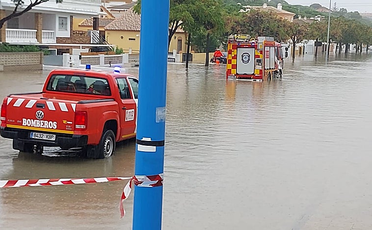 Imagen principal - Bomberos circulando por Mazagón para resolver incidencias y vista de la Avenida Cristóbal Colón desde la Cafetería París