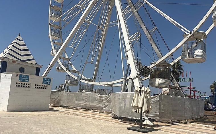 Imagen principal - La noria situada en el Paseo Marítimo de Matalascañas y abajo un camión grande en la arena y las grietas causadas por la piscina