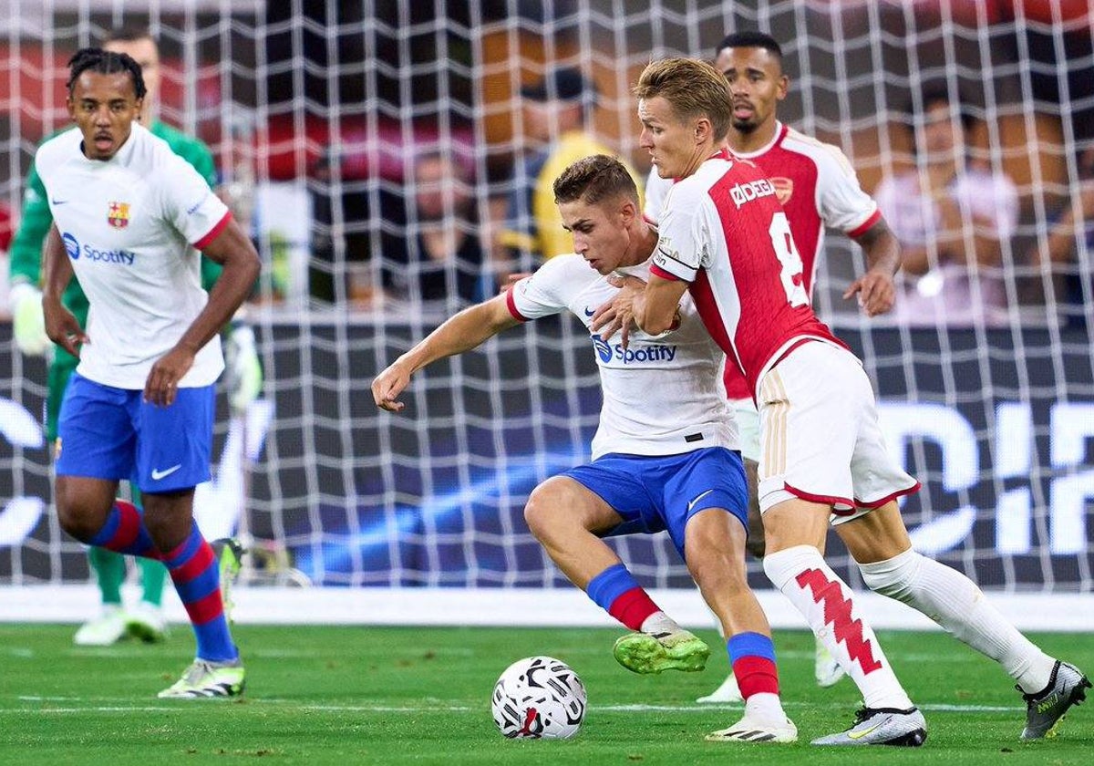 Fermín López presionado por Odegaard en presencia de Koundé durante el Arsenal-Barcelona